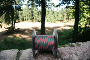 Burgundy and Hunter Green Solid Braided Multifilament Polypropylene Rope on a Stone Wall