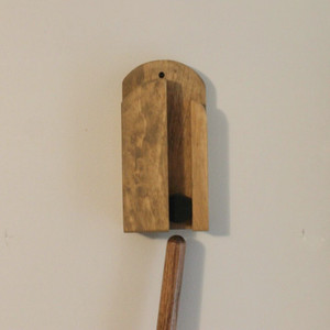 Step 1: Broom handle in position under the wall mounted holder ready to insert.