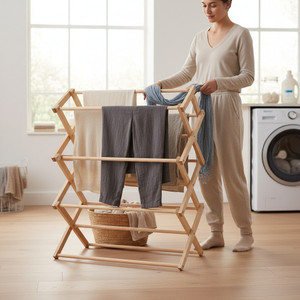 Wooden folding clothes drying rack with laundry in a bright modern laundry room