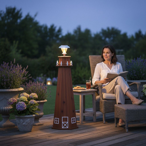 Solar-powered cedar lighthouse garden statue lighting a backyard patio at dusk.
