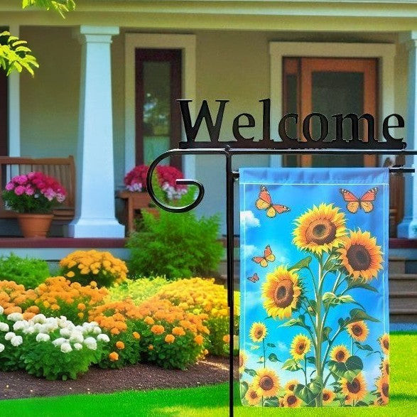 Decorative garden flag with sunflowers and butterflies in front of a house with 'Welcome' sign.