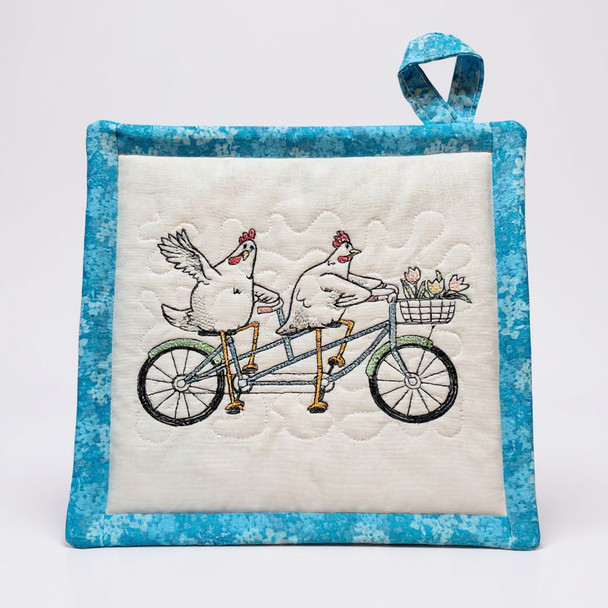 New pattern of Chick Bike Potholder/Hot Pad  with striking blue pattern on the back. Brighten up your kitchen with this cute design from Crows Nest Quilters and Harvest Array.