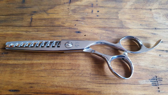 Shear Fanatic™️ Scissor Shear Fanatic®️ Craft Series Yellow Jacket 10 Tooth Texturizing Shears, metallic craft hair scissors with a serrated blade and curved handle on a wooden surface.
