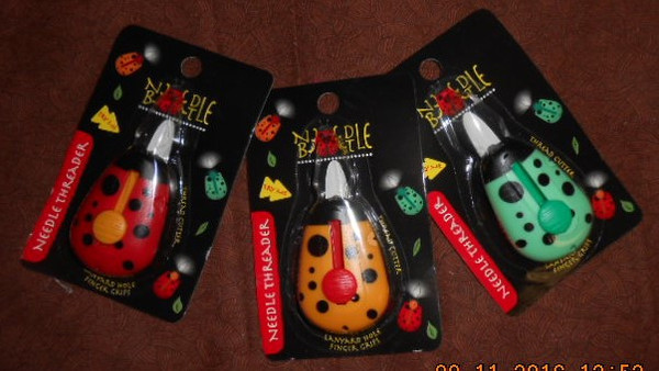 A view of the NeedleBeetle Needle Threaders in their packaging (various colors)