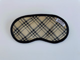 The Notting Hill eye mask is designed with a preppy tan and plaid that has black silky fabrics that will keep your eyes nice and comfy.