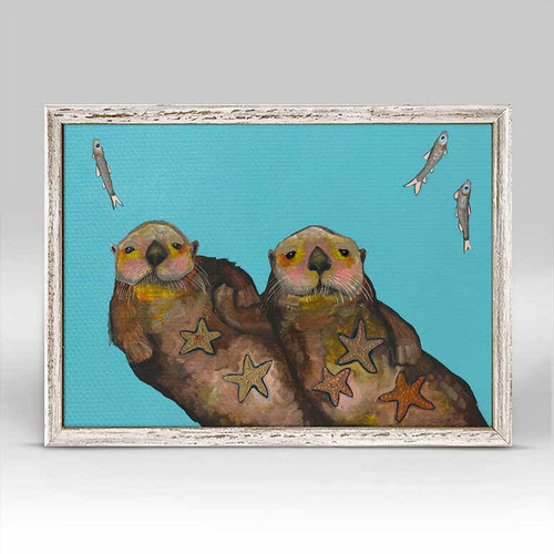 These otters are incredibly endearing as they are indeed holding hands so as not to be swept apart. Finished in a rustic white frame, they’ll sit easily on your shelf or wall.