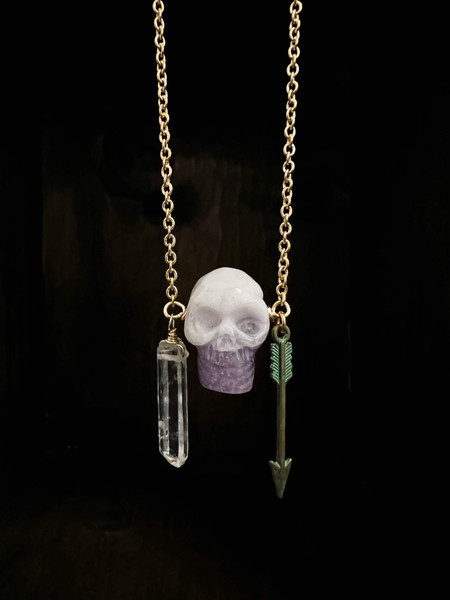 Carved amethyst skull with dangling Quartz point and arrow charm hanging on 33” brass chain with 24K Russian gold filled lobster clasp.