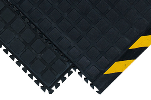Corner of black Hog Heaven Modular tile. One has a beveled edge with yellow striped border, and the other edge is black with interlocking mechanisms. Another black tile is underneath with the corner showing: both sides of tile have the interlocking mechanisms. Corner of black Hog Heaven Modular tile. One has a beveled edge with yellow striped border, and the other edge is black with interlocking mechanisms. Another black tile is underneath with the corner showing: both sides of tile have the interlocking mechanisms.