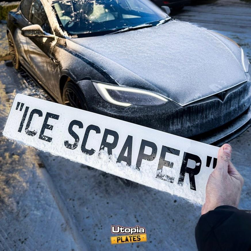 The Utopia Plates "ICE SCRAPER" in front of a Tesla Model S covered in snow