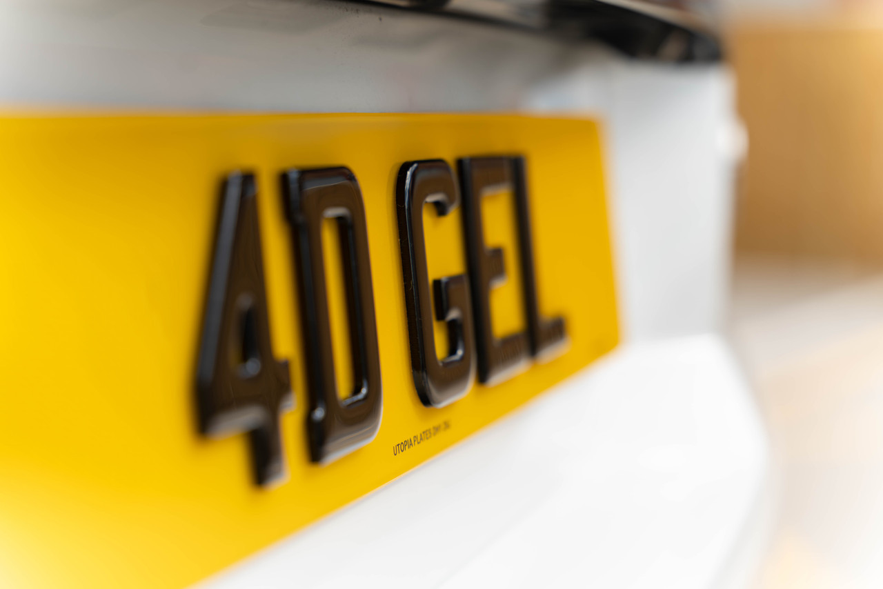 Close-up side view of a 4D 3mm with gel rear number plate, showing the gel dome over each raised character
