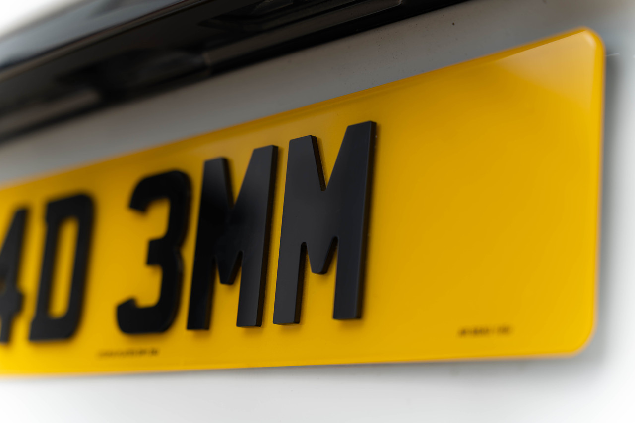 Angled close-up of a 4D 3mm rear number plate showing the cut edge of each character