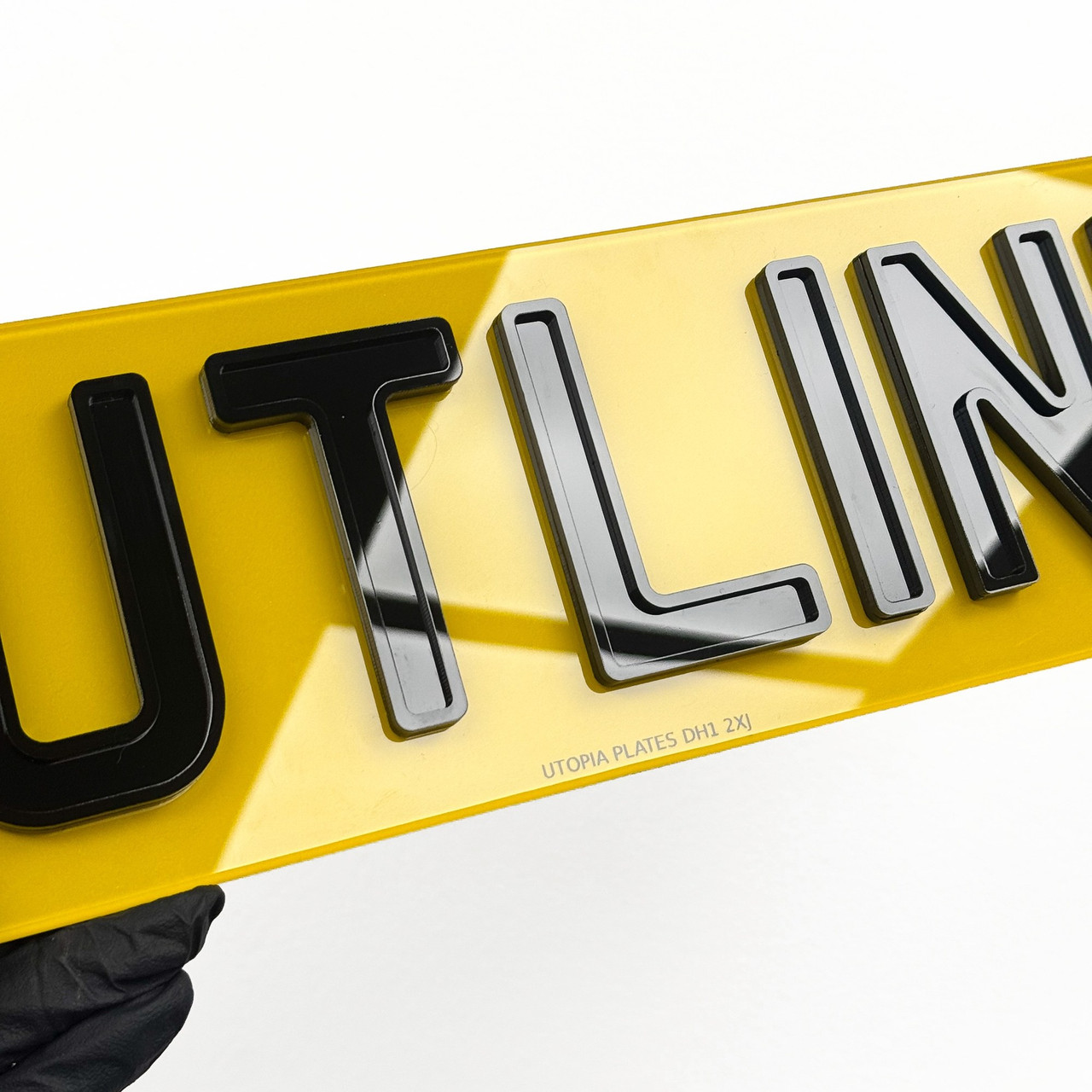 Close-up of 3D gel number plate lettering, showing the resin dome over each character