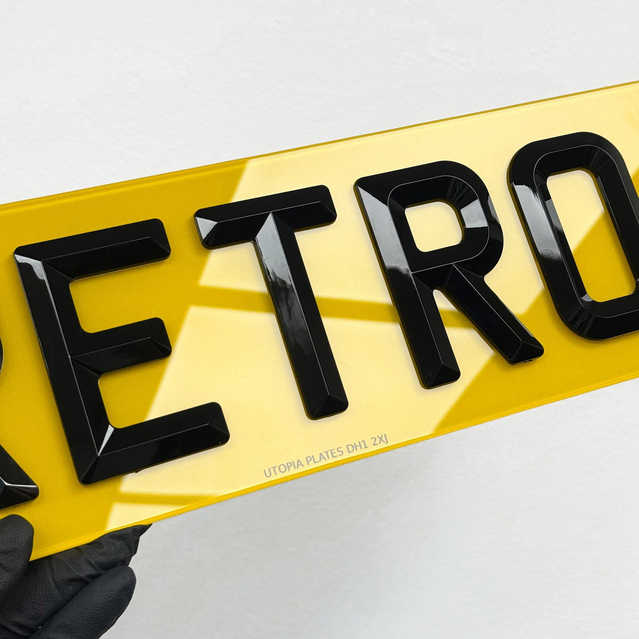 Close-up of retro style number plate letters, showing the high gloss black finish pyramid characters