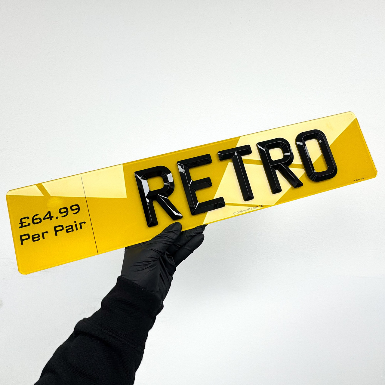 Retro number plate shown at an angle, showing the deep gloss finish of the raised characters