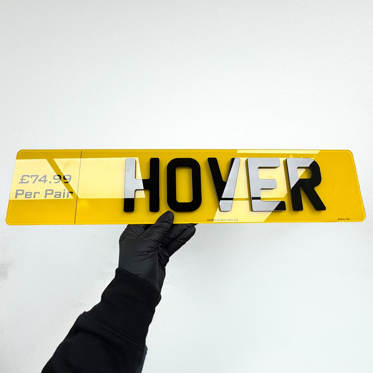 Hover number plate held at an angle, showing the layered black lettering