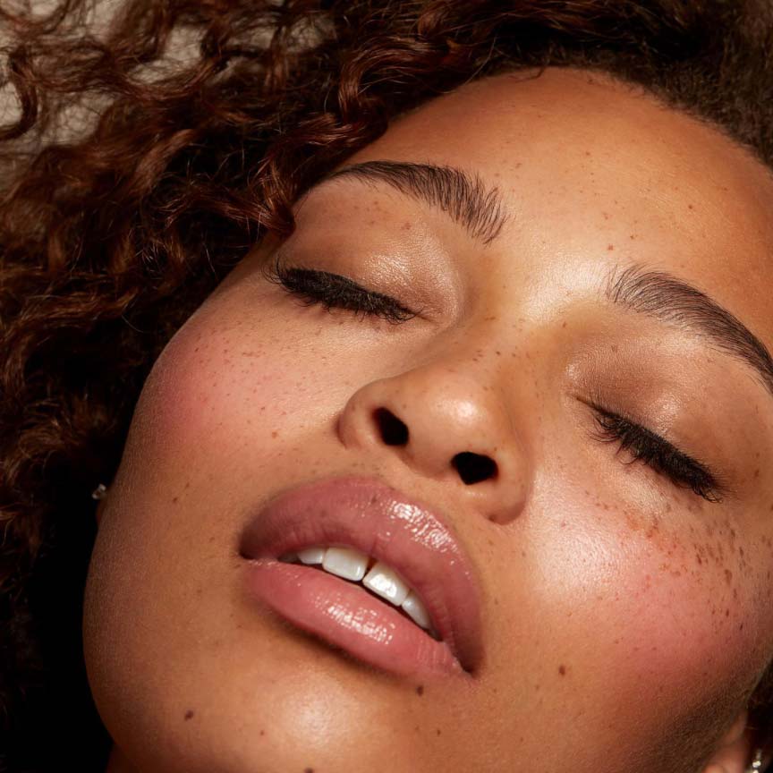 Red curly haired woman with Seint makeup.
