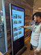 Customer using a 55-inch, 500nit 24x7 touchscreen digital poster kiosk rated for 30,000 hours of operation.