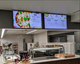 Two 55" LG Lite Duty Smart Screens mounted over a service counter, displaying pizza menu options.