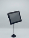 Studio shot of the wireless 6.1" WAND Smart Label hardware unit, highlighting its sleek black bezel, compact standalone profile, and mini digital signage screen attached to a 6" Black Metal Elegant Smart Tag ESL Holder