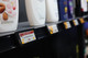 A retail shelf displaying various beauty products with digital labels highlighting new arrivals.