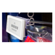 A T-Wire swing-up mount securing a digital price label to a thin wire shelving fixture.