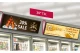 Two 37 inch LG Ultra Stretch smart screens mounted with a 30-degree tilt above retail refrigeration units.