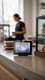 A Wand Digital 4.0 smart label on a cafe counter displaying a lavender oat milk latte, with a barista working in the blurred background.