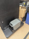 Angled view of an Anker SOLIX power unit secured in a black accessory tray attached to a commercial display.