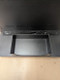 Black rectangular accessory catch tray with raised edges attached to the base of a digital display.