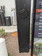 Close-up of a black menu-mounted speaker-mic housing attached to a drive-thru menu display.