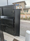 Rear view of a digital drive-thru kiosk showing the mounting bracket for a speaker-mic housing.