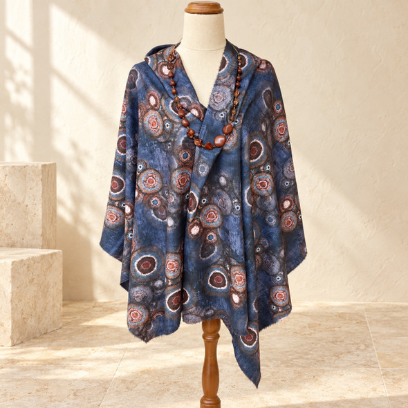 Blue circular print shawl draped over a cream mannequin with a coordinating brown resin and shell bead necklace.
