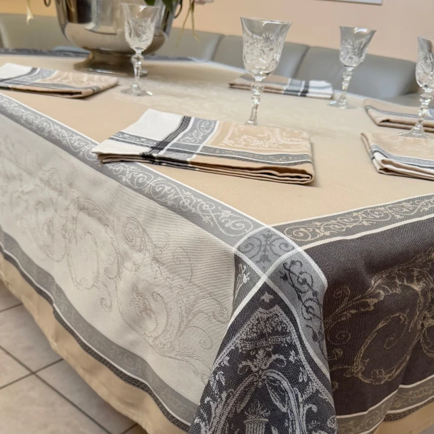 Versailles Beige French jacquard tablecloth with ornate grey borders, matching fabric napkins and crystal glasses