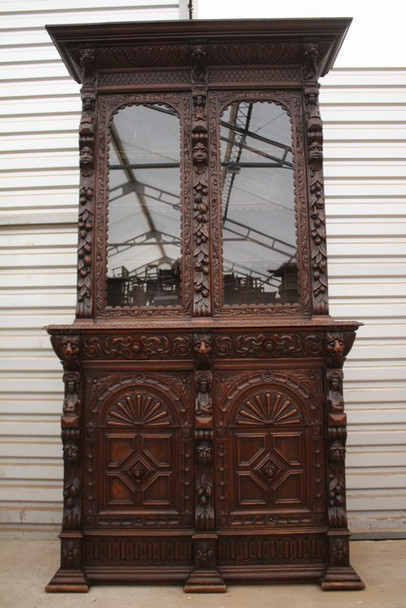 Antique French Renaissance Revival oak buffet cabinet – Henri II style, late 19th century, with carved lions, grotesques, and busts – two-part cabinet with drawers and mirrored upper section.