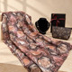 Brown and coffee print shawl with a black and brown necklace, floral cosmetic bag and black gift box with burgundy ribbon.