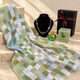 Full gift set: Green checked scarf gift set with coordinating necklace, Green Apple Eau de Toilette 100ml and black gift box with burgundy ribbon.