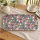 William Morris Red Lily melamine sandwich tray, 40 × 20 cm, on beige linen with a cup and flower jug