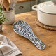 William Morris Willow Bough melamine spoon rest on a wooden kitchen bench beside a cream cooking pot and utensil holder