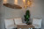 Graphenstone Siena Chalky Grey Dining Room with three white chairs, wood table and green plant behind.