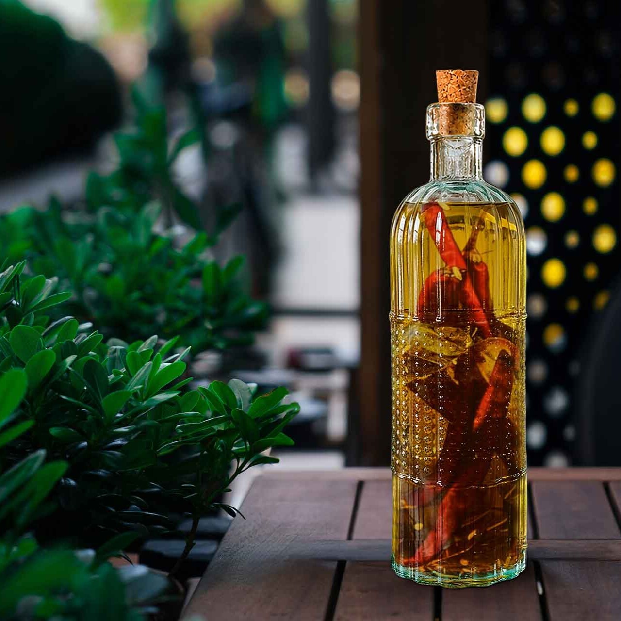 16 oz Tuscany Recycled Glass Bottle with Olive Oil and Chili Pepper Infusion on Outdoor Picnic Table at Restaurant