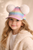 Girl wearing colorful pom pom cap, playful kids fashion accessory