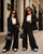 12 and 14 year old Two stylish girls wearing luxury black oversized suits with gold accessories and mini handbags in a modern editorial fashion scene inspired by elevated kids street style and contemporary luxury fashion.