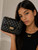 Girl modeling the Coco Quilted Junior black quilted handbag with gold hardware and chain strap.