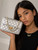 Girl modeling the Coco Quilted Junior silver metallic quilted handbag with gold hardware and chain strap.