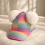 Girl wearing colorful pom pom cap, playful kids fashion accessory