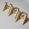 three guitar wall hangers in solid white ash wood option pictured on a white tabletop