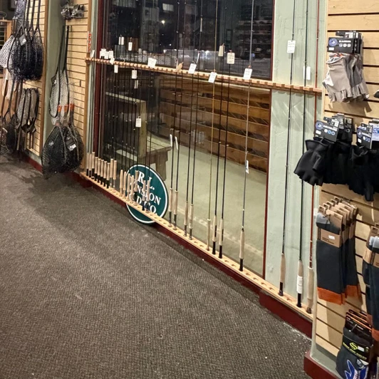 Fly rod rack from CSCarpentry installed across window in outfitter storefront
