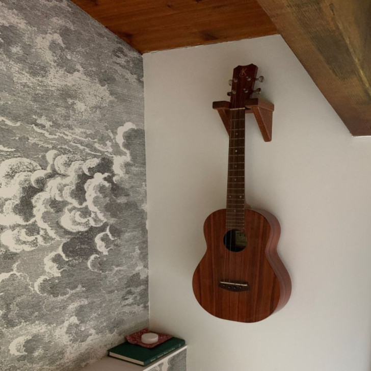mahogany ukulele wall hanger, installed on wall with ukulele hanging