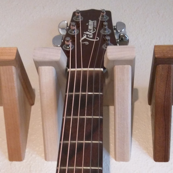 Solid poplar wood guitar hanger installed on wall with guitar