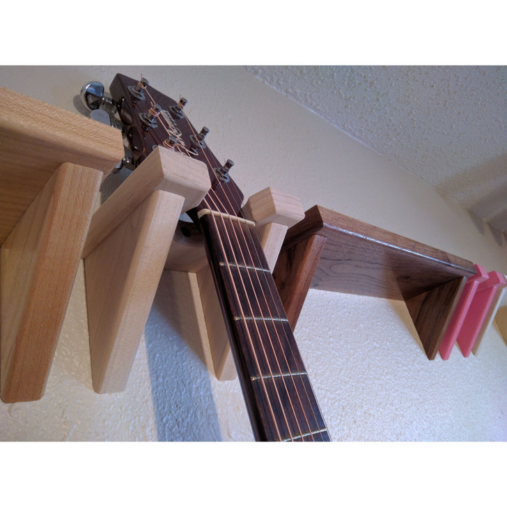 Solid poplar wood guitar hanger installed on wall with guitar